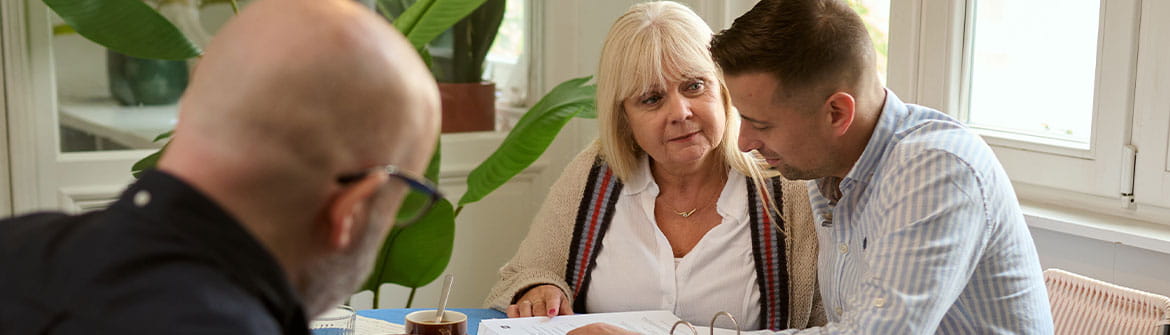 Des personnes discutent ensemble de documents lors d’une conversation portant sur des choix pratiques et la préparation.