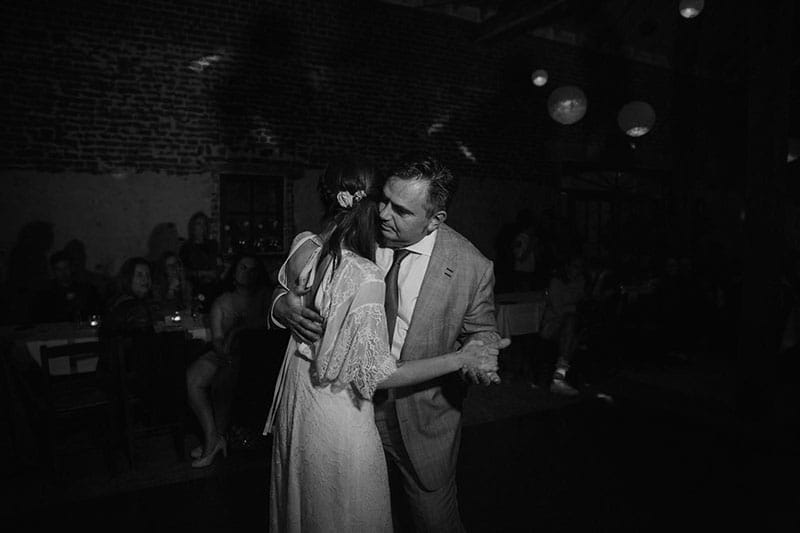 Twee personen dansen samen op een feest in een verduisterde zaal.