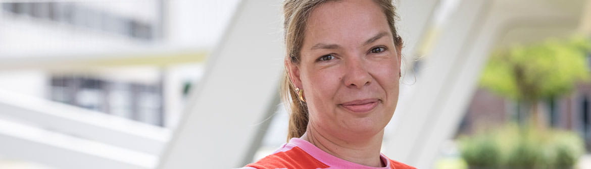  Een persoon staat buiten bij een moderne overkapping tijdens een interviewmoment 