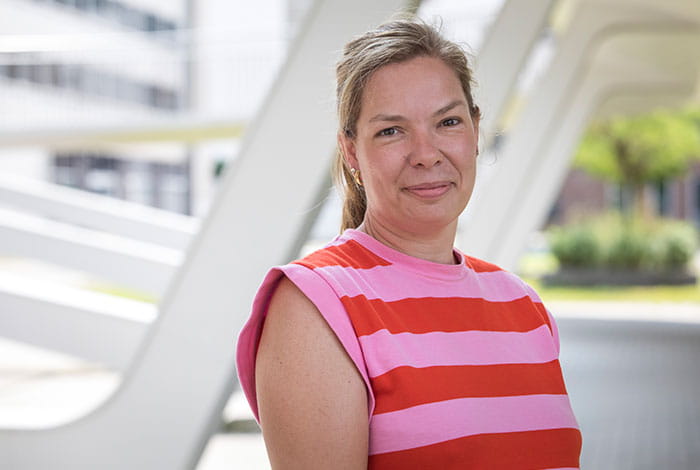  Een persoon staat buiten bij een moderne overkapping tijdens een interviewmoment 