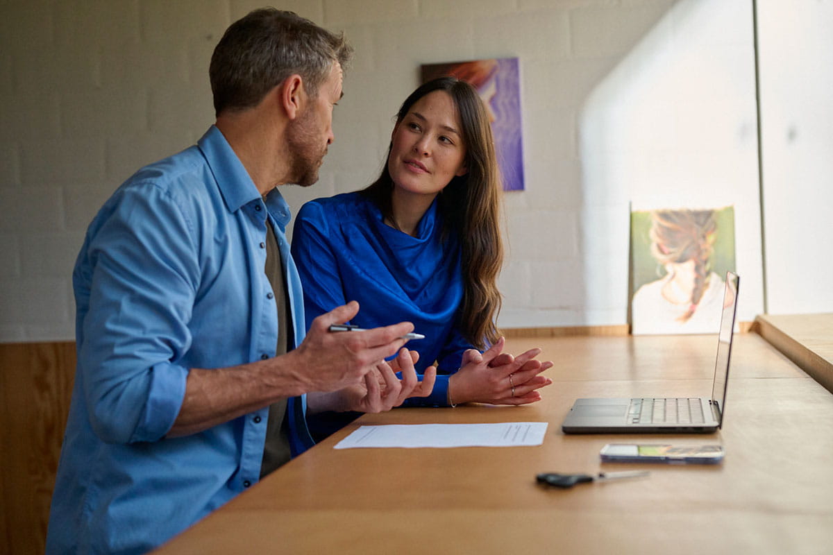 Homme et femme en discussion dans un bureau.